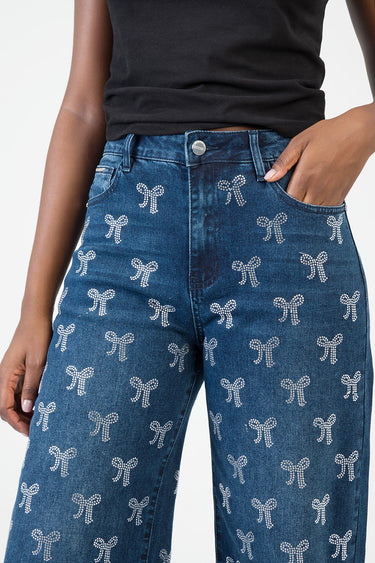 model wearing blue high waist wide leg jeans with white bow embroidery and front pockets by Blue Jean Traders