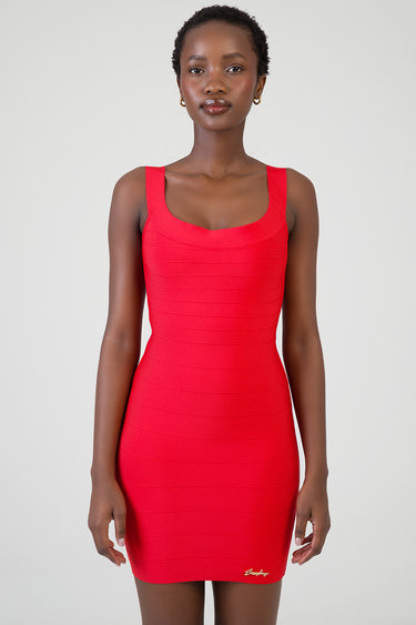 woman wearing a red sleeveless bodycon mini dress with wide straps and horizontal seam lines, small gold logo at hem