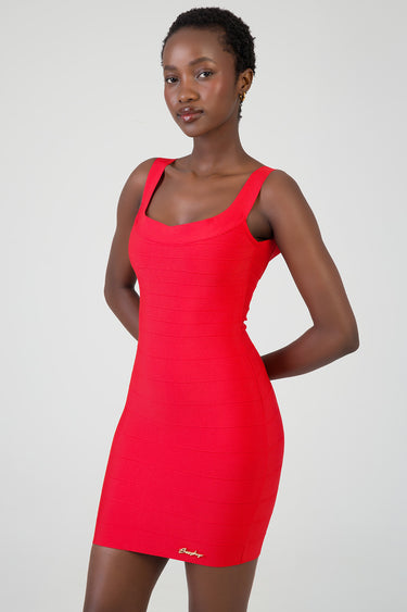 woman wearing a bright red sleeveless bodycon mini dress with wide straps and horizontal banding, gold logo at the hem