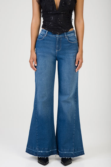 model wearing blue wide leg jeans with a high rise, subtle fading and frayed hem, paired with a black lace top