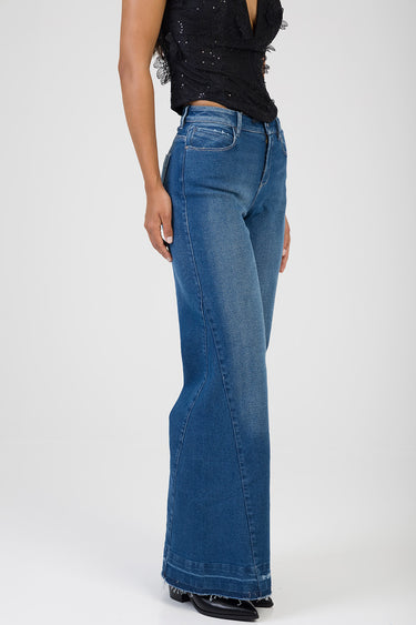 side view of a model in blue wide leg jeans with a black sequined lace top
