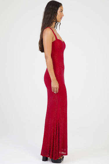 side profile of a red maxi dress studded with small rhinestones, fitted bodice and flowing skirt, model wearing black