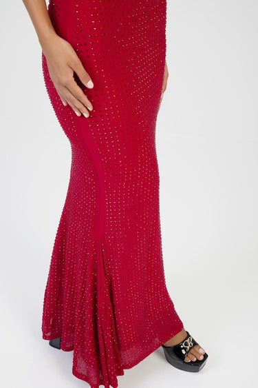 red maxi dress covered in rhinestones, fitted through the hips with a flared hem, paired with black sandals