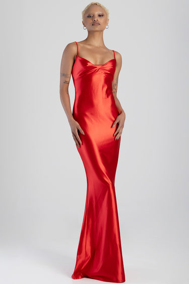 model wearing red satin maxi dress with thin straps and twisted bust, full length silhouette
