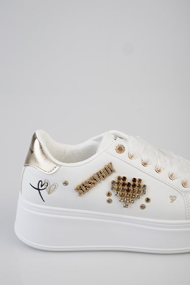 Blue Jean Traders white platform sneaker with gold metallic heel and jewel stud accents on the side