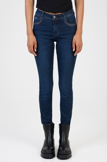 woman wearing dark blue skinny jeans with light stitching, front view, with black boots