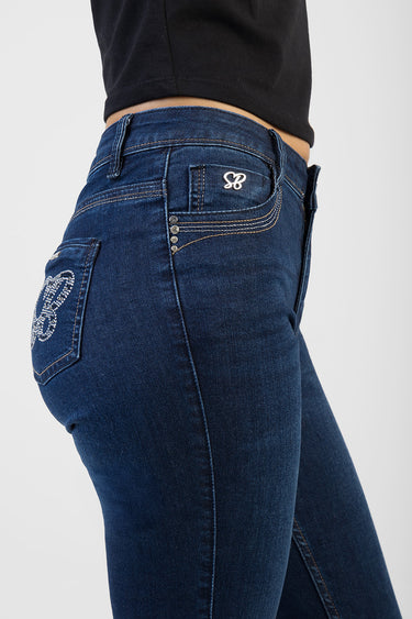 blue denim skinny jeans on a model, waist and back pocket with rhinestone embroidery and metal rivets
