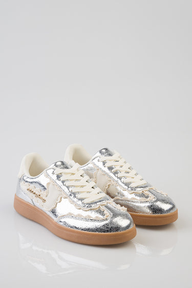 two silver metallic sneakers with cream laces and gum sole on a white background
