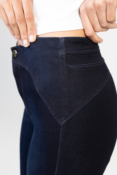 dark indigo denim jeans close up of back pocket and waistband with visible stitching and metal button