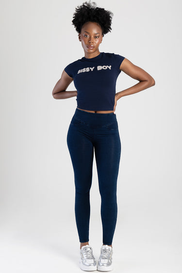 woman wearing navy cropped top with glitter text and dark indigo skinny jeans with silver sneakers