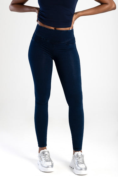 woman wearing high-waisted dark indigo knit denim jeans with white sneakers