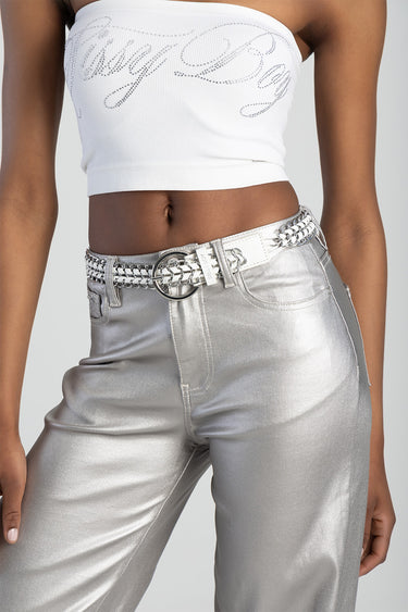 silver chain belt with large rings around the waist over metallic silver pants and a white cropped top