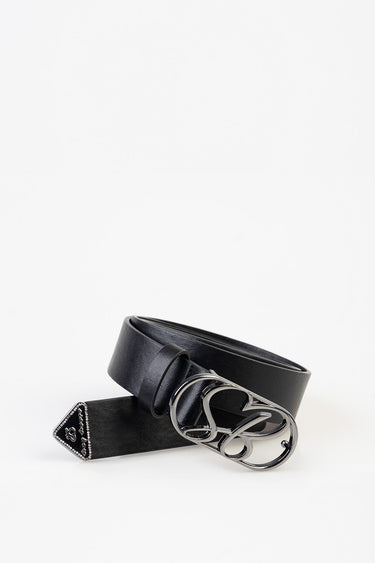 black leather belt with a large shiny silver buckle and studded triangular tip