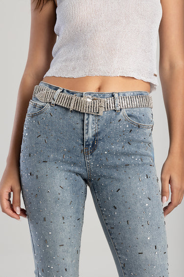 midriff view of a rhinestone waist belt on blue jeans with scattered metallic beads