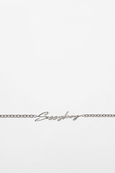 silver chain belt with a cursive word pendant laid on a white background