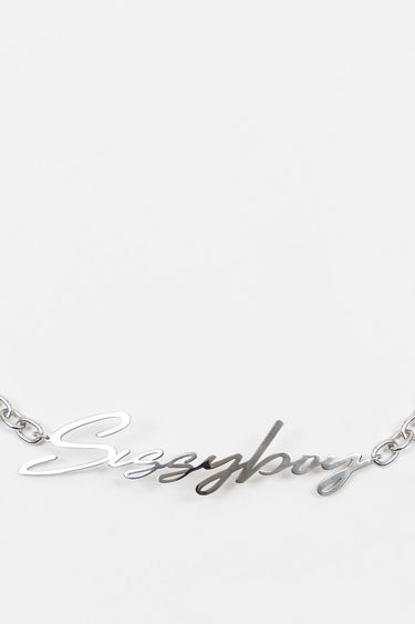 silver script necklace with a cursive word pendant on a thin chain against a white background