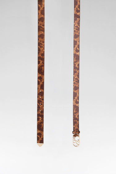 leopard belt by Blue Jean Traders with a gold buckle hanging beside a slender brown belt with a metal tip