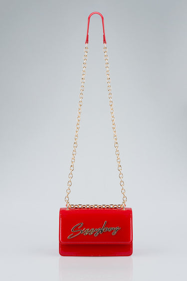 red crossbody bag with a gold chain strap and cursive logo on front