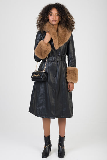 woman in a black leather trench coat with camel fur collar and fur cuffs, belted waist, carrying a black crossbody bag with
