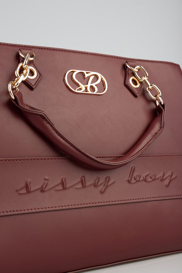 burgundy shopper bag with gold chain handles and embossed script on the front.