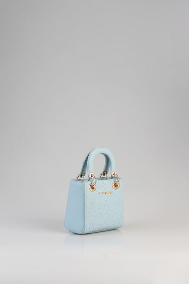 Blue Jean Traders mini tote bag in light blue with embossed pattern and gold ring hardware