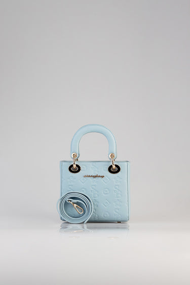 light blue mini tote bag with embossed pattern, two rounded handles, gold hardware, and a detachable strap