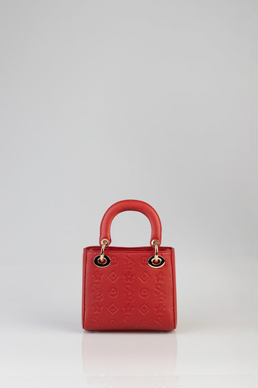 red tote bag with two rounded handles and gold ring hardware, embossed pattern across the surface