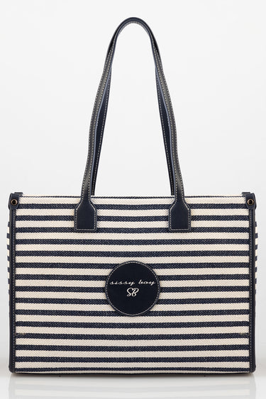 navy and white striped tote bag with dark leather handles and a round patch on front