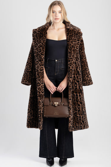 woman wearing a leopard print faux fur coat, black top and dark jeans, holding a brown structured handbag by Blue Jean