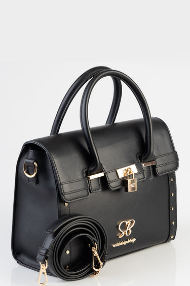 black leather tote bag with two top handles, a gold lock, gold initials on front, and a detachable strap coiled beside.