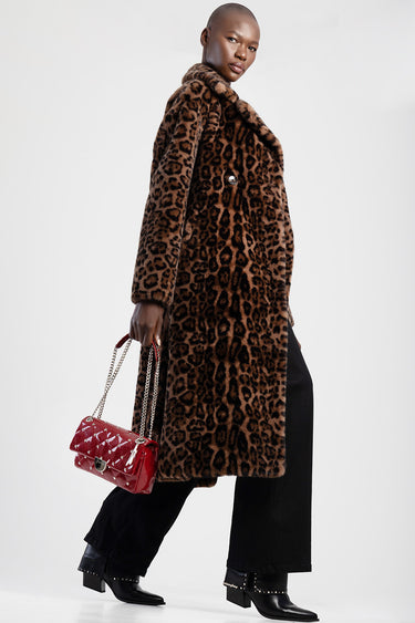 woman wearing a leopard print faux fur coat holds a red quilted handbag with a chain strap
