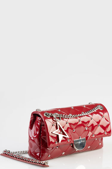 red patent leather quilted handbag with a silver chain strap, star charm, and small metal studs