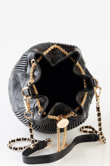 black bucket bag with ribbed sides and gold chain straps, open top showing dark interior and circular gold hardware