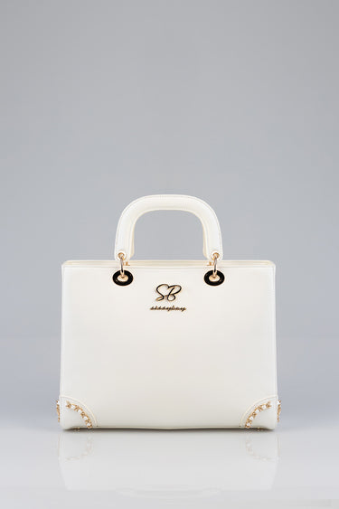 white structured handbag with rounded top handles and gold rings, front logo initials sb and script below, gold chain