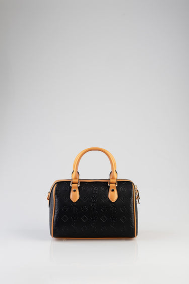black bowler bag with tan leather handles and trim, embossed pattern across the surface, gold tone hardware