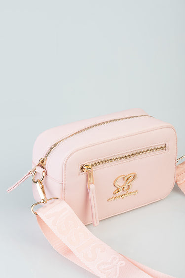 pink crossbody bag with gold zippers and a wide patterned strap by blue jean traders