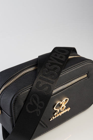 black crossbody bag with gold zippers and a front logo monogram, adjustable patterned strap