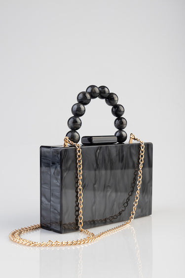 black marbled clutch with a glossy finish, spherical black bead handle and gold chain strap