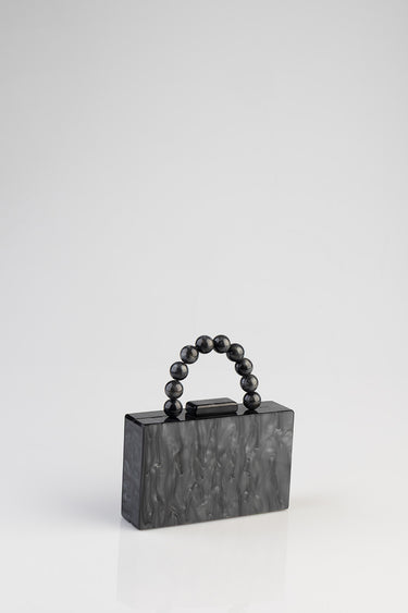 black marbled clutch bag with a circular bead handle
