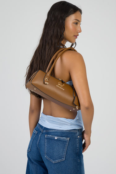 woman wearing a tan brown leather shoulder bag with gold hardware and logo on the side