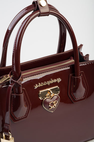 burgundy patent leather tote by Blue Jean Traders with gold hardware and a heart charm
