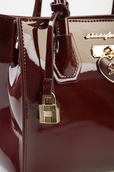 burgundy patent leather tote by Blue Jean Traders with gold lock charm and stitched detailing