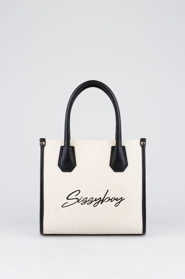beige canvas handbag with black leather trim and handles, front features scripted sissyboy logo