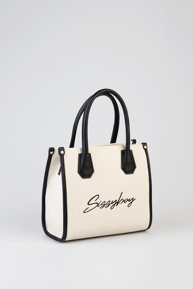 cream canvas tote with black trim and double top handles; front features cursive logo text in black