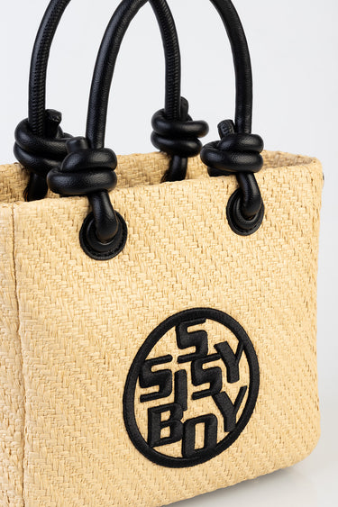 woven straw tote bag with black knotted handles and a circular Blue Jean Traders logo