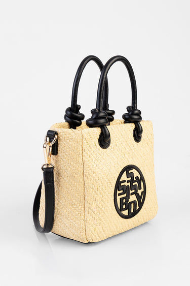 beige woven straw tote with black knotted handles and a circular logo patch on front
