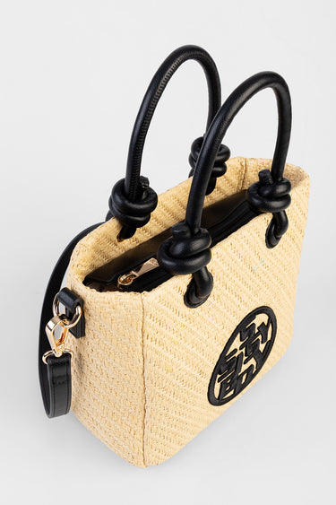 straw handbag with black knotted handles, gold zipper, and a round Blue Jean Traders logo patch