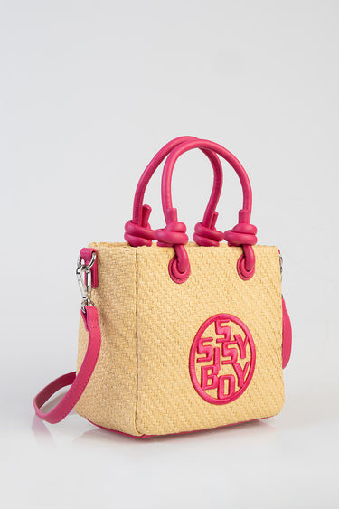 straw tote bag with pink knotted handles and a circular pink logo patch on the front
