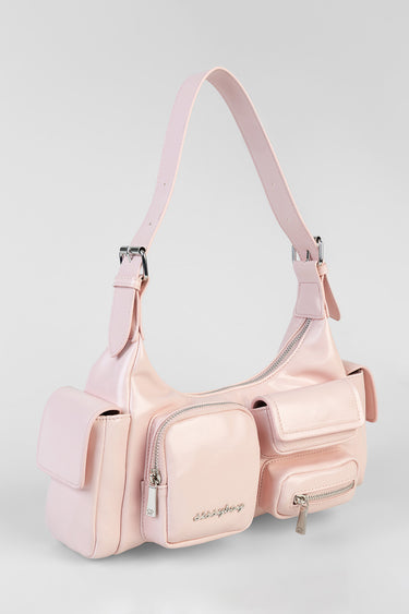 pink handbag with several front pockets, zippered compartments and a single shoulder strap.