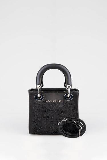 small black handbag with floral embroidery, two rounded top handles, silver hardware, and a detachable long strap